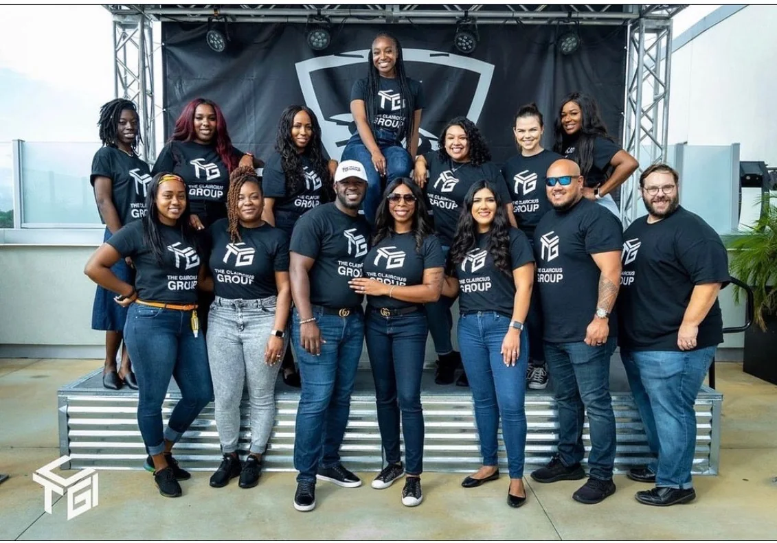 The Claircius Group team on stage, wearing branded shirts